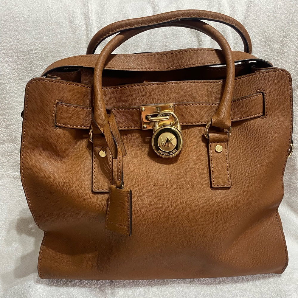 Micheal Kors brown purse with crossbody strap, comes with padlock and key.